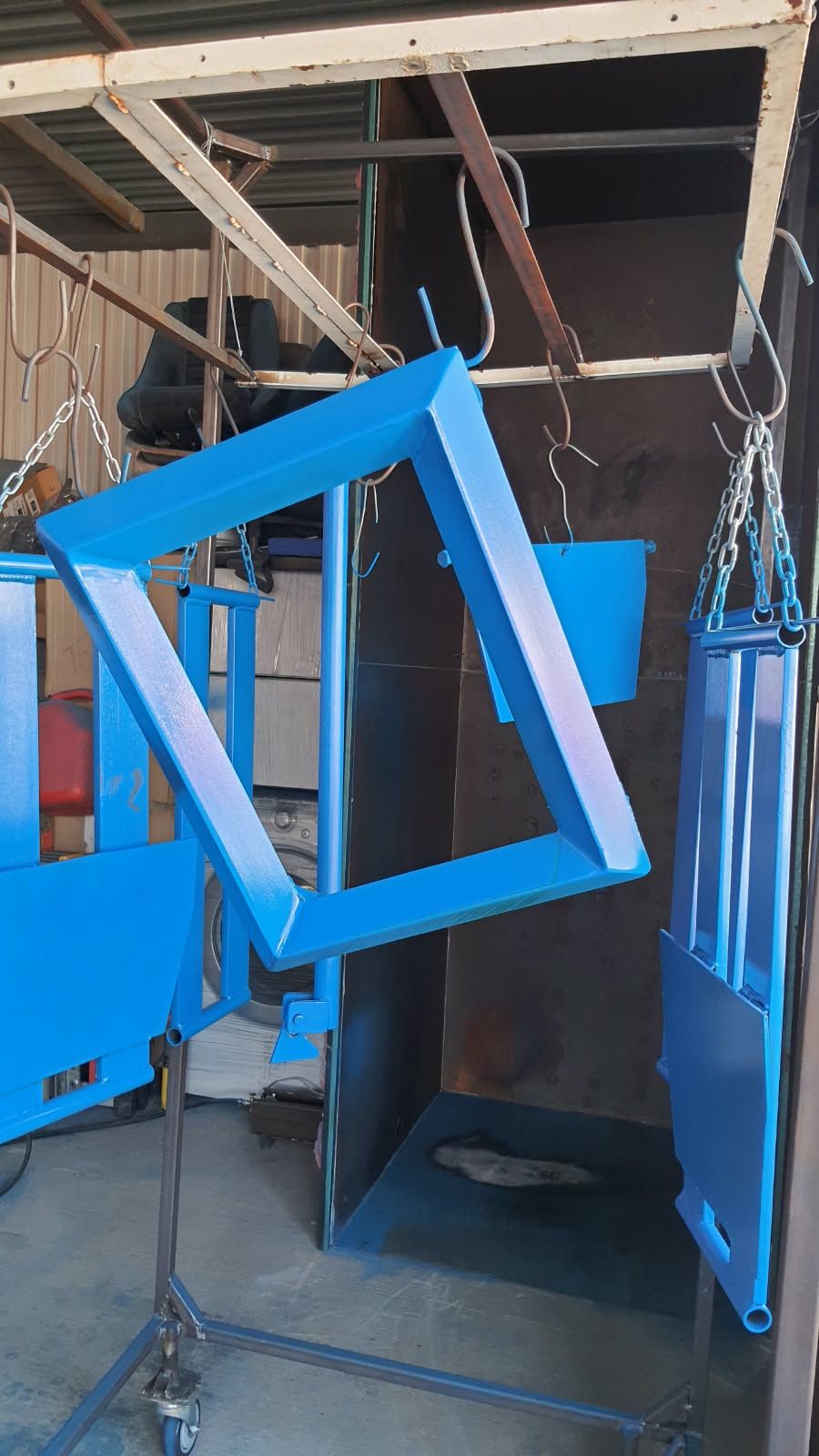 Marco metálico en forma de rombo con acabado azul y otras piezas azules colgadas